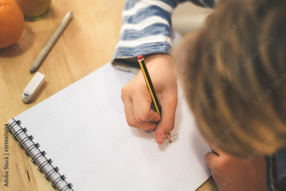 Close up view of student drawing with pencil. Boy doing homework writing on a paper. Kid hold a pencil and draw a manga at home. Teen drawing sitting at the table. Education art talent ability concept Close up view of student drawing with pencil. Boy doing homework writing on a paper. Kid hold a pencil and draw a manga at home. Teen drawing sitting at the table. Education art talent ability concept