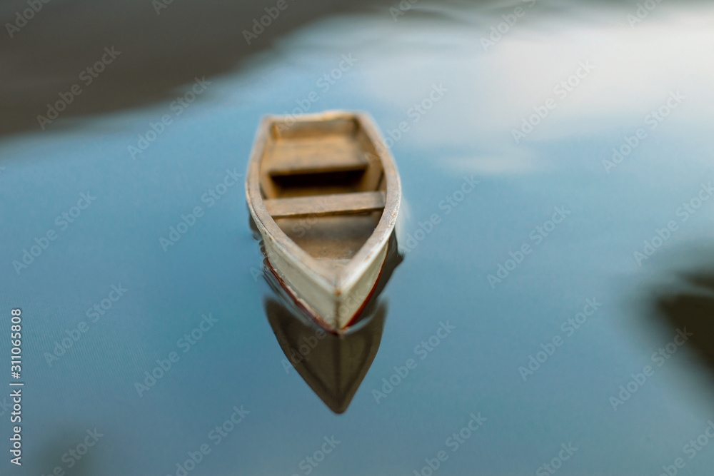 Small wooden boat on the water. A small boat is floating on the