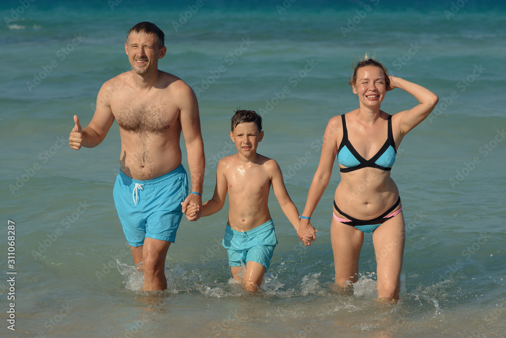 Portrait of family of three people spending time on beach on summer vacations. Portrait of family of three people spending time on beach on summer vacations.