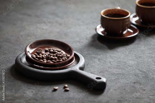 Still life black coffee in a Cup with coffee beans on a dark background
