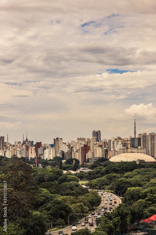 Skyline da cidade de São Paulo, com destaque para zona sul, prédios e céu parcialmente nublado.