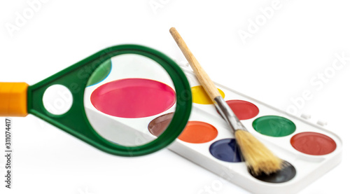 Watercolor paints looking through Magnifying glass on white. Choice colour.