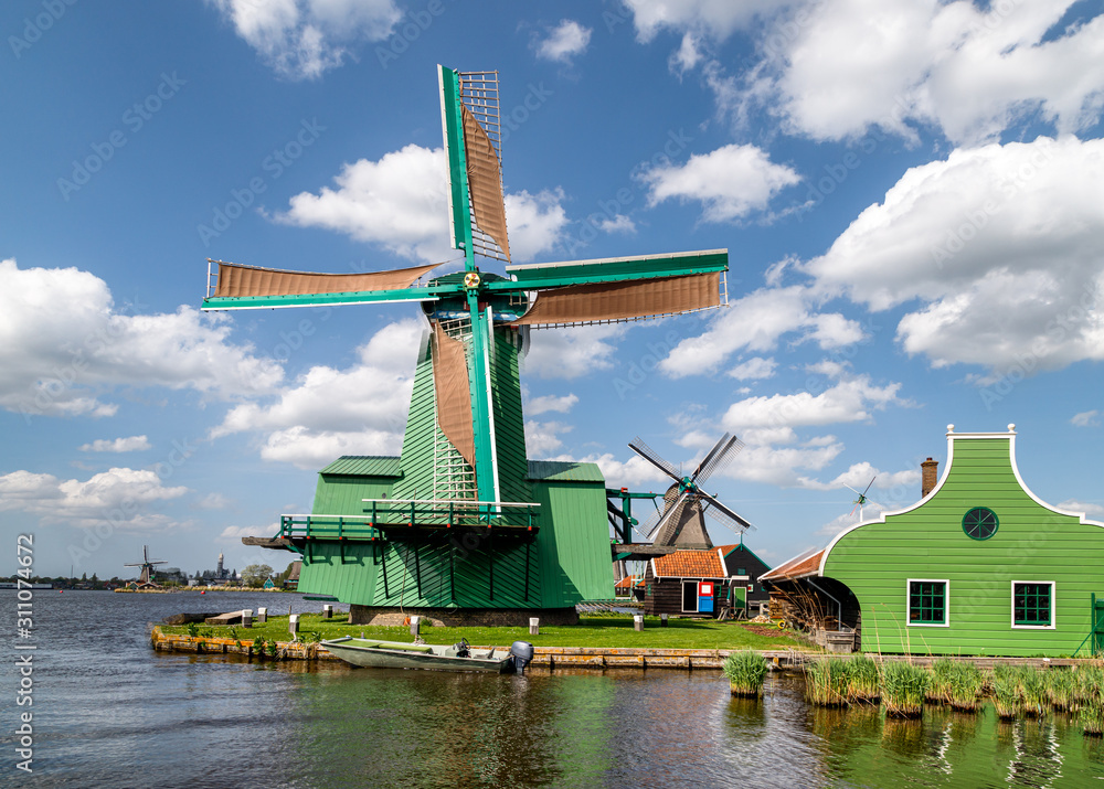 Authentic dutch windmills on the water channel in the historic village of Zaanse Schans, a neighbourhood of Zaandam, near Amsterdam in the Netherlands.