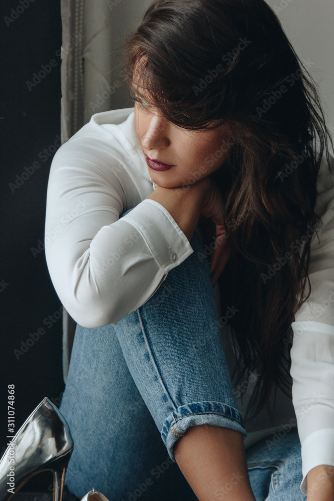Fototapeta premium Beautiful young woman wearing white blouse and blue jeans