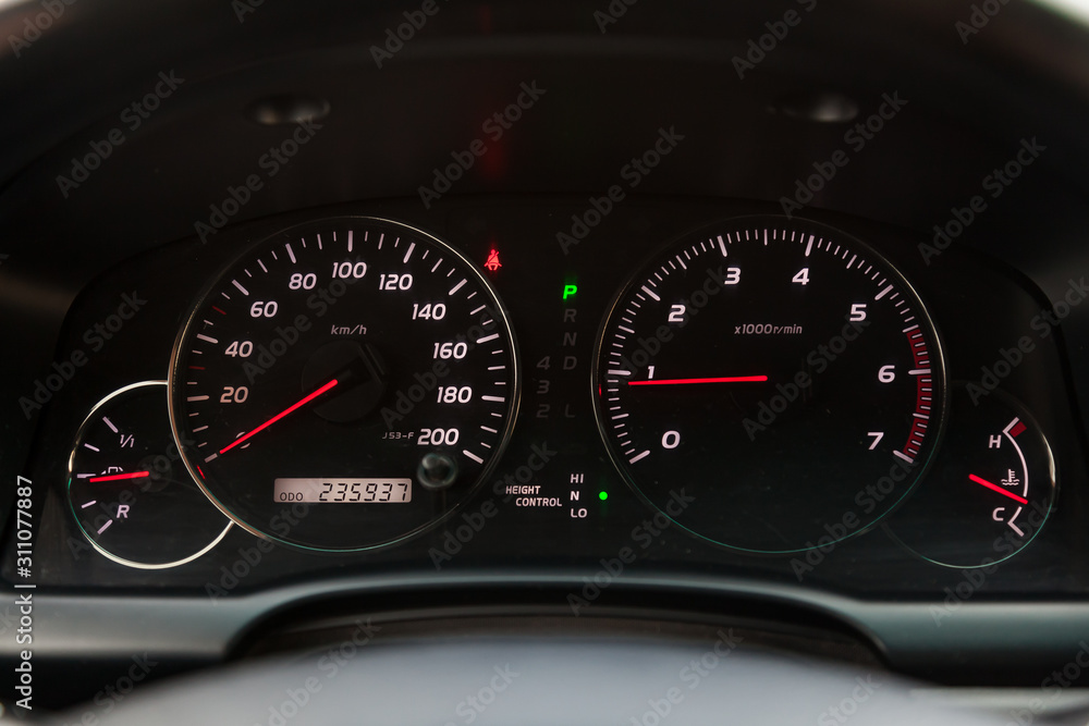 The dashboard of the car is glowing blue with red arrows at night with a speedometer, tachometer and other tools to monitor the condition of the vehicle in modern style on black isolated background The dashboard of the car is glowing blue with red arrows at night with a speedometer, tachometer and other tools to monitor the condition of the vehicle in modern style on black isolated background