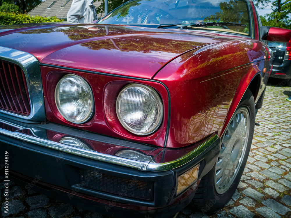 Detail shot of headlight of a red vintage car