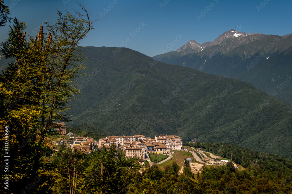 several beautiful hotels of a ski resort on a slope of a forested mountain several beautiful hotels of a ski resort on a slope of a forested mountain