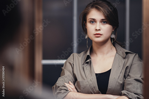 portrait of a stylish woman looking in the mirror confidently, reflection of a beautiful young woman getting ready for work, concept female success and lifestyle