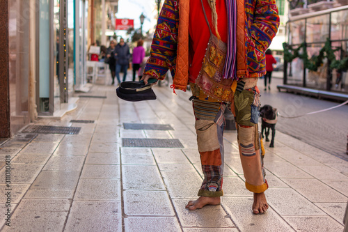 Old Man in Colorful Clothes asking for Alms on the street during Christmas Period