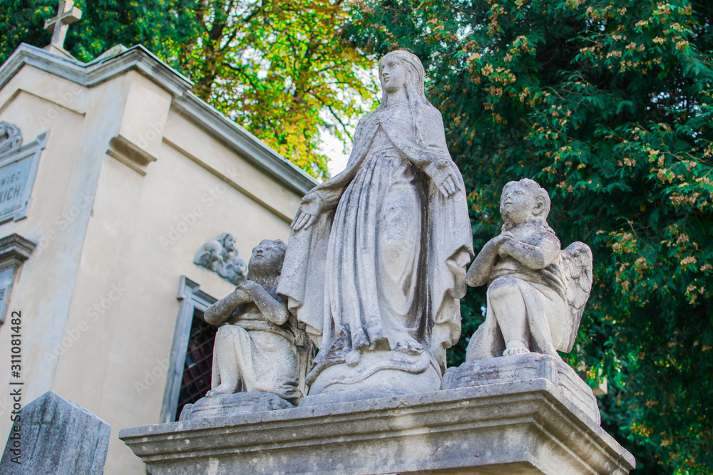 Stone statue of St. Mary and the angels in the park.