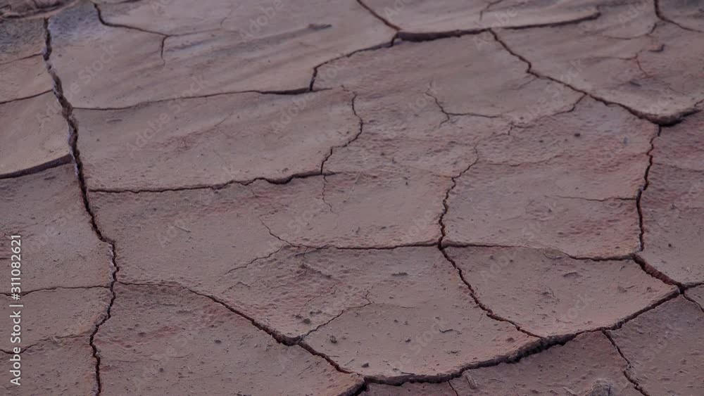 Cracked red clay and white salt on the surface in a dried riverbed in the desert of New Mexico, USA Cracked red clay and white salt on the surface in a dried riverbed in the desert of New Mexico, USA