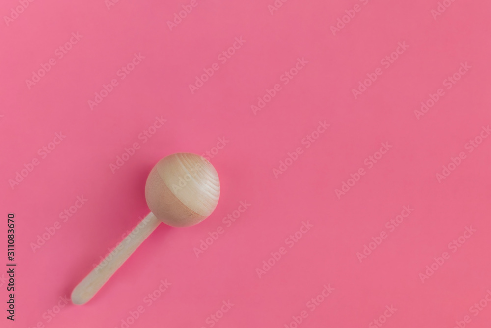 Wooden baby rattle on a pink background. Flat lay, hand made, copy space, top view, toy. Wooden baby rattle on a pink background. Flat lay, hand made, copy space, top view, toy.