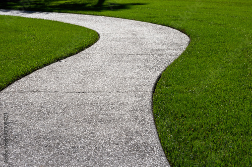 A thick carpet of zoysia grass and an oyster shell tabby pathway suggest the abstract concept of a journey, or of a beautifully maintained garden.
