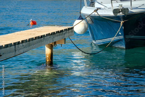 Closeup bow view of motor boat parked to a wooden pier