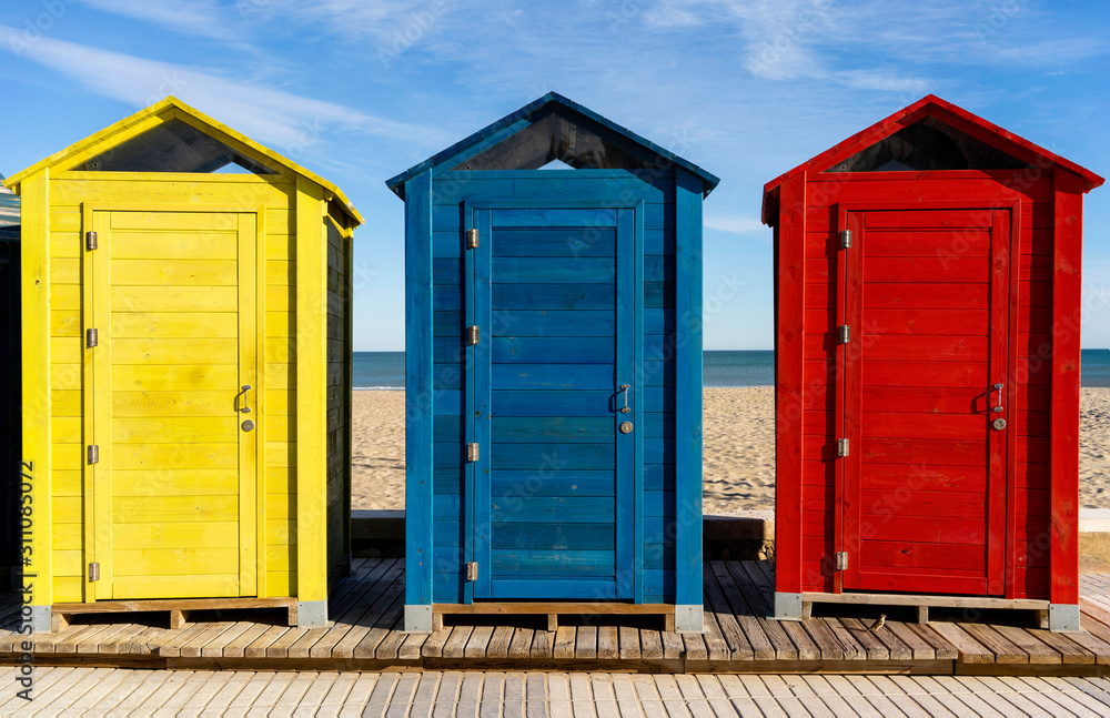 row of beach huts cabins in front of beach see and sand row of beach huts cabins in front of beach see and sand