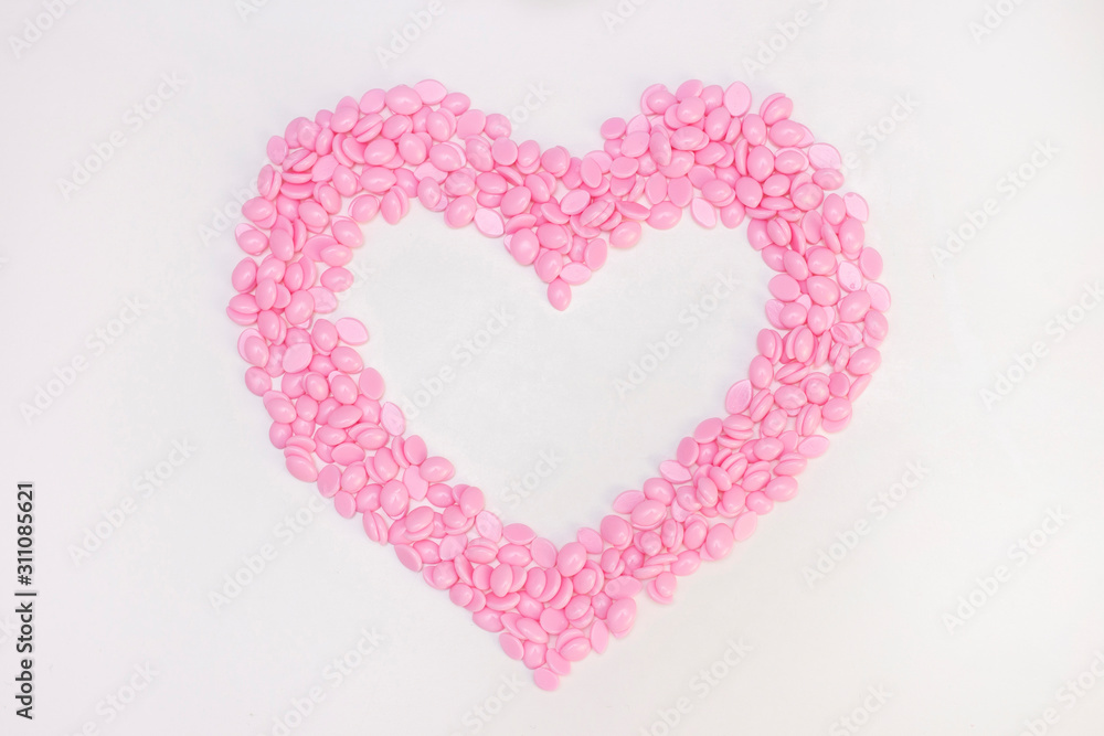 Wax for depilation of pink color. in the form of a heart. On white background. The concept of waxing, smooth skin.