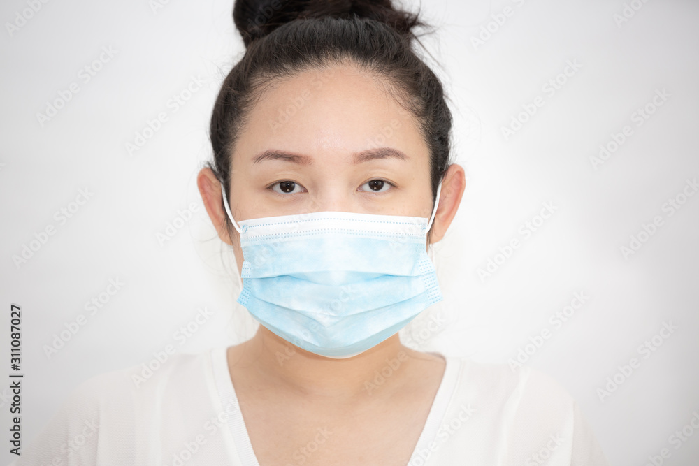 The image of a young Asian woman wearing a mask to prevent germs, toxic fumes, and dust. Prevention of bacterial infection in the air in a white background The image of a young Asian woman wearing a mask to prevent germs, toxic fumes, and dust. Prevention of bacterial infection in the air in a white background
