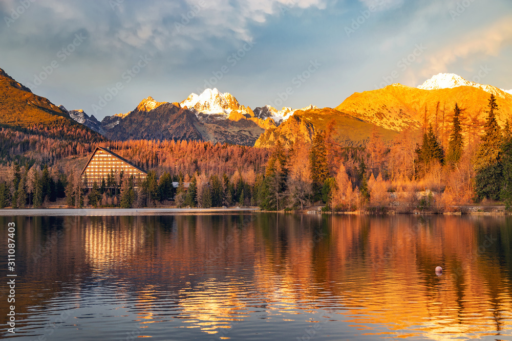 High Tatras panorama during autumn sunset. Lake Strbske pleso with lighted landscape.