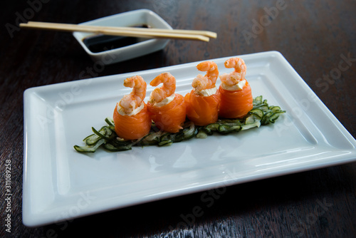 salmon cucumber and cream cheese shrimp sushi in a white plate shoyo and chopstick sauce, asian food, japanese cuisine photo