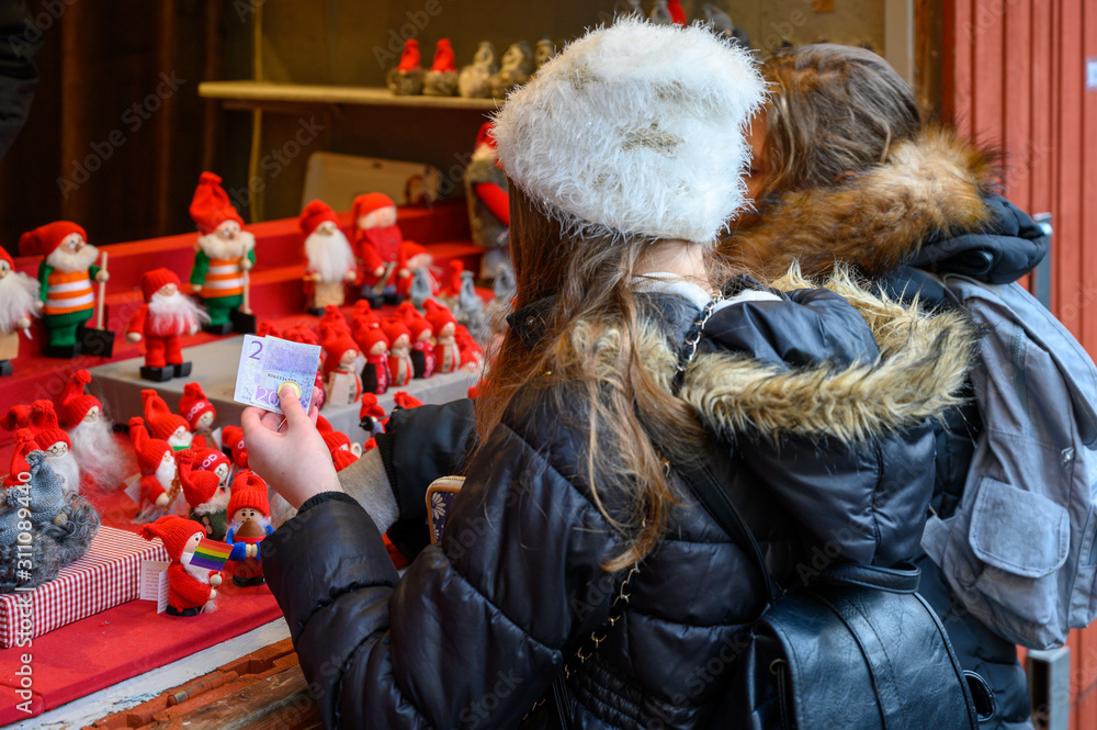 Obraz premium Girl purchases gifts in the Christmas market in Stockholm Old Town