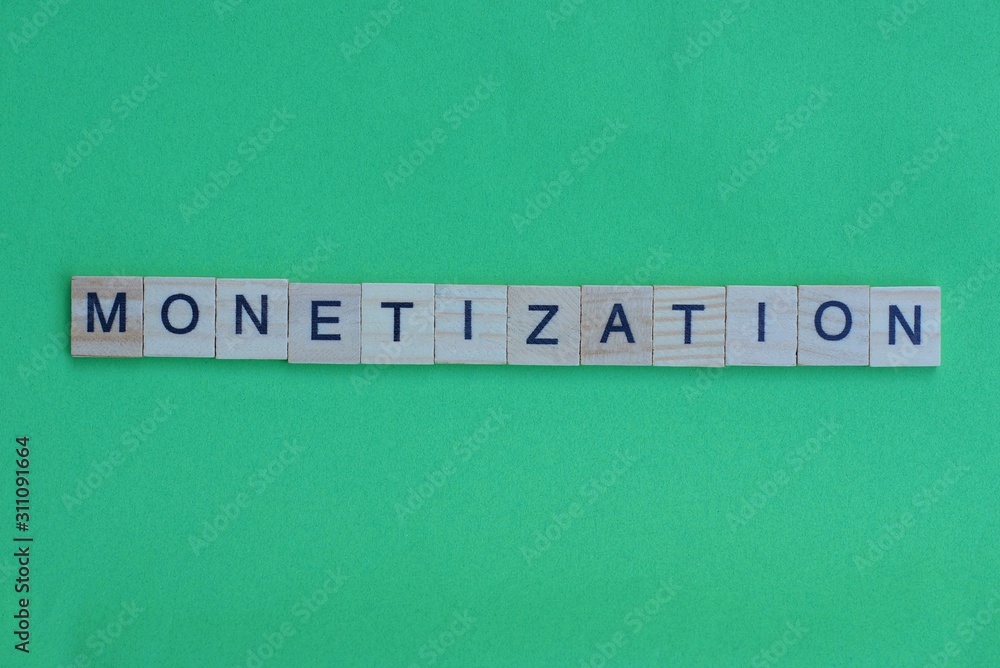 word monetization made of small gray wooden letters on a green paper background word monetization made of small gray wooden letters on a green paper background