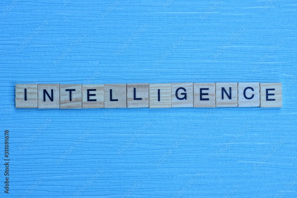 word intelligence made of small wooden letters on a light blue paper background word intelligence made of small wooden letters on a light blue paper background
