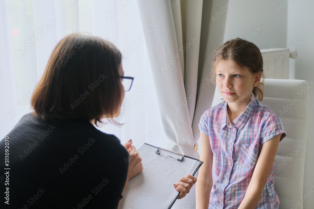Obraz premium Woman social worker psychologist talking to girl child in office