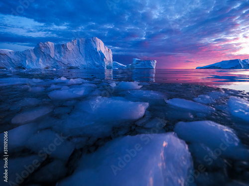 Iceberg at sunset. Nature and landscapes of Greenland. Disko bay. West Greenland. Summer Midnight Sun and icebergs. Big blue ice in icefjord. Affected by climate change and global warming. photo