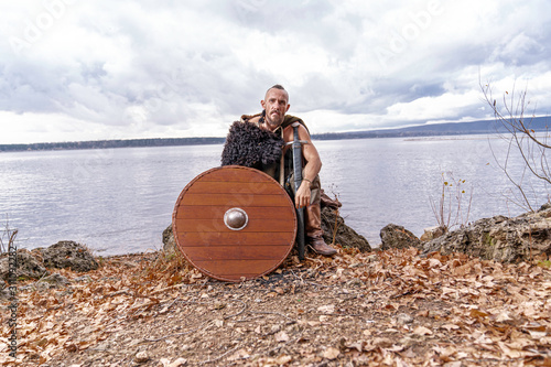 Viking sits on the river bank