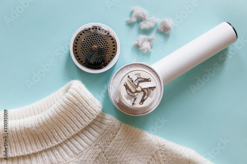 Tableau sur toile Pilling/ Man hand holding lint remover from a white acrylic or wool sweater