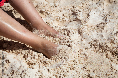 Close up Picture of Middle Age Woman's Feet inside White Sand on the beach during a sunny day. Taken on Brownes Beach, Saint Michael, Barbados.