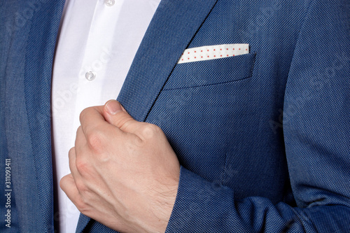 Male hand of businessman holding the edge of his classic blue blazer  photo