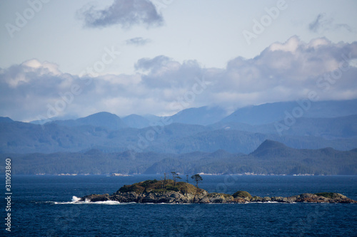 Northern Vancouver Island, British Columbia, Canada. Rocky Islands on the Pacific Ocean during a sunny and cloudy day with Islands and the Mainland in the background.