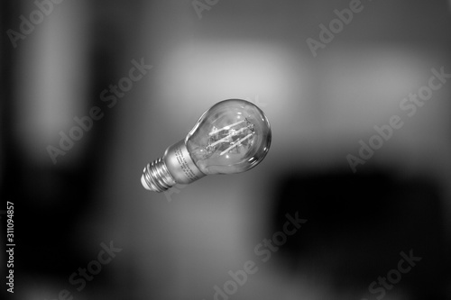 Levitating light bulb in black and white