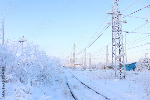 Snow-covered railway among the trees. Rails going into the distance. Winter landscape. Selective focus.