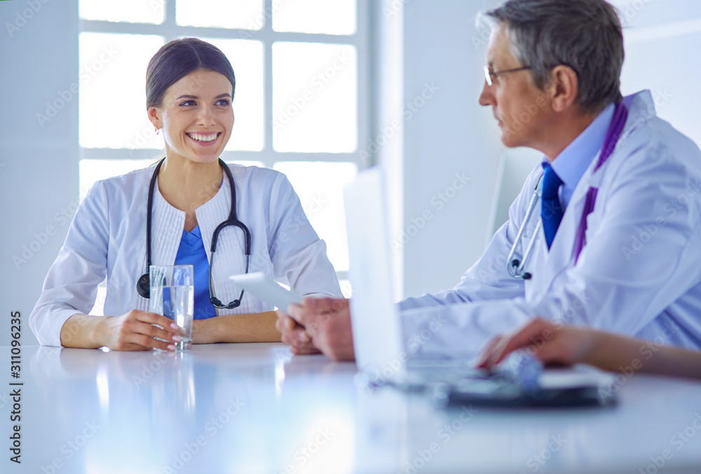 Doctors consulting with each other in a hospital conference room Doctors consulting with each other in a hospital conference room