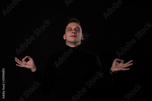 Calm man relaxing meditating, no stress free relief at work concept, mindful peaceful young businesswoman or student practicing breathing yoga exercises on isolated over black background.