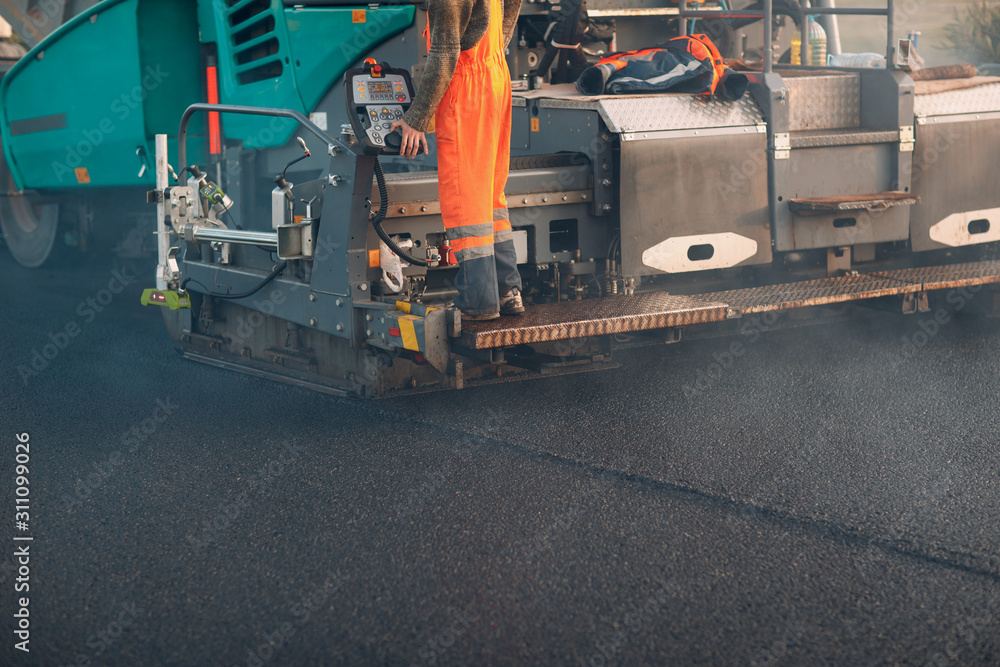 Asphalt paving. Paver machine. New road construction.