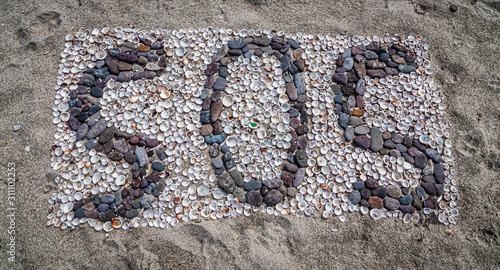 SOS message on the beach with stones and shells