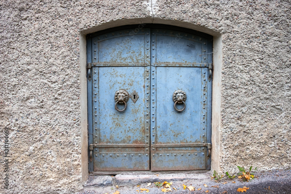 Old rustic cellar doors with lion door knocker.