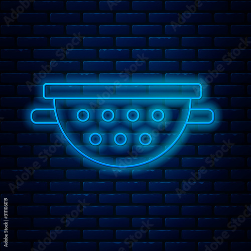 Glowing neon line Kitchen colander icon isolated on brick wall background. Cooking utensil. Cutlery sign. Vector Illustration