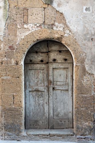 Old wooden door in the stone wall.  © Maciej