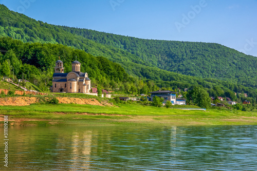 Landscape side view of Orthodox church on the shore of Lake..Spring in National Park Mavrovo, North Macedonia.