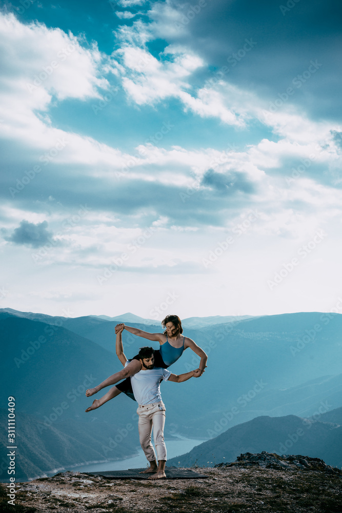 Two athletic young dancers making a performance on a mountain