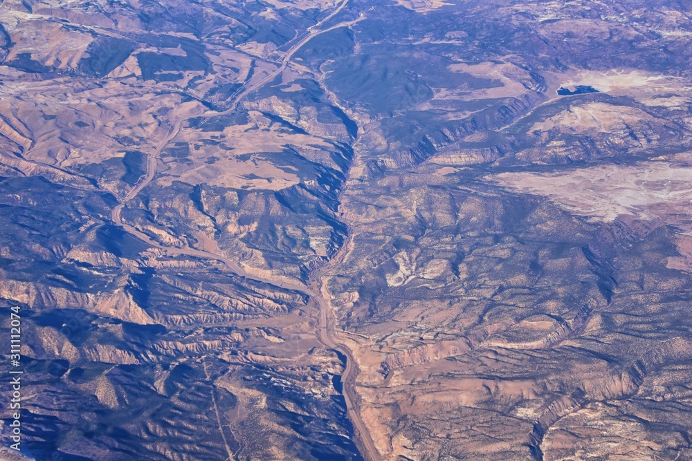 Fototapeta premium Colorado Rocky Mountains Aerial view from airplane of abstract Landscapes, peaks, canyons and rural cities in southwest Colorado and Utah. United States of America. USA.