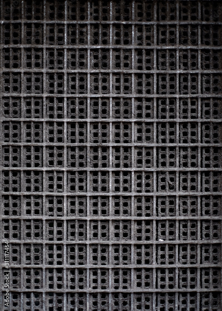 A dark rectangular pattern with repetitive square texture, an element of vent system, a minimal architecture detail. A dark rectangular pattern with repetitive square texture, an element of vent system, a minimal architecture detail.