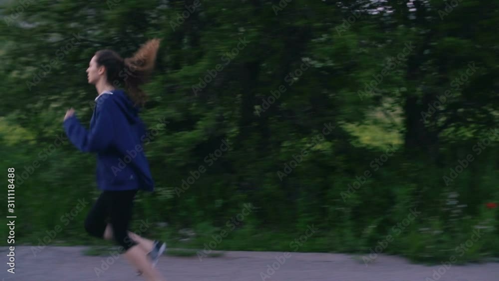 Two woman and one man running onin park at sunset training intense cardio endurance workout. Runner enjoying evening run slow motion Two woman and one man running onin park at sunset training intense cardio endurance workout. Runner enjoying evening run slow motion