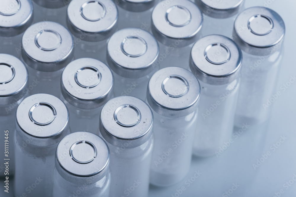 Glass medical ampoule vial for injection. Medicine is dry white drug penicillin powder or liquid with of aqueous solution in ampulla. Close up. Bottles ampule with aluminum cap on backgrounds gray. Glass medical ampoule vial for injection. Medicine is dry white drug penicillin powder or liquid with of aqueous solution in ampulla. Close up. Bottles ampule with aluminum cap on backgrounds gray.