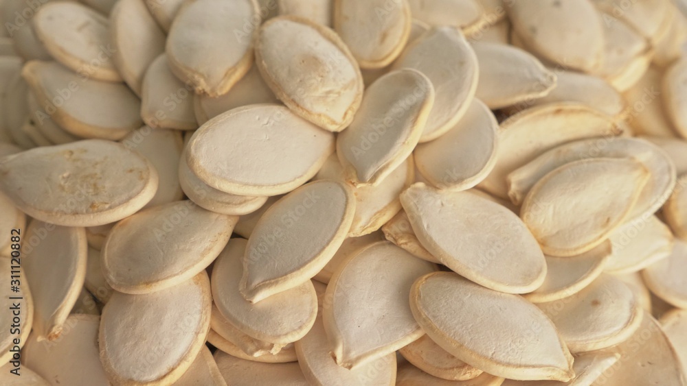 Nuts unpeeled pumpkin seed rotate are on a table in a plate. Snack in transparent dish on an isolated white background are spinning moving. Delicious and healthy protein-rich diet food. Nuts unpeeled pumpkin seed rotate are on a table in a plate. Snack in transparent dish on an isolated white background are spinning moving. Delicious and healthy protein-rich diet food.