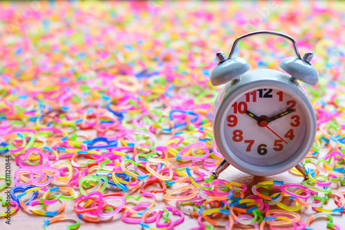 A clock is ten o'clock on shaped colorful Slingshot colorful heart theme and soft green background. photo